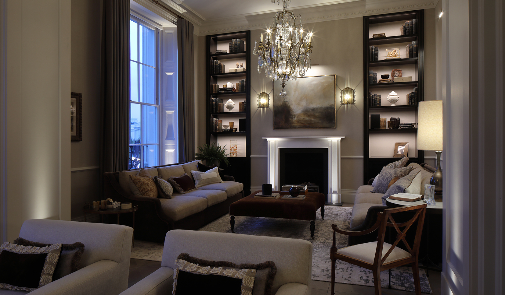 heritage living room with shelf lighting and uplights to the fireplace