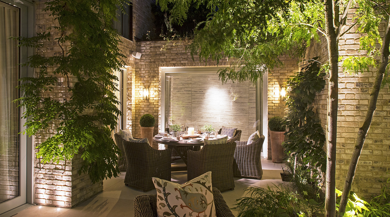 alfresco dining with softly lit surrounding garden