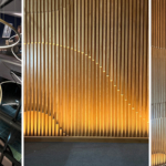 Office atrium with long circular pendant and uplit slated wooden wall