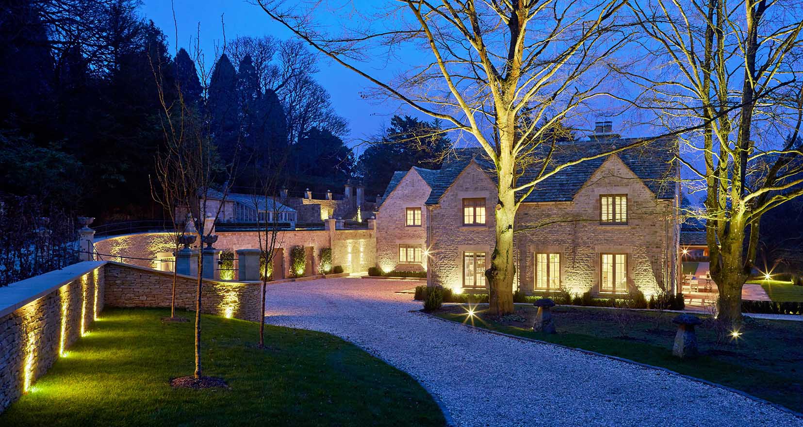 drive to country house with uplit wall and exterior