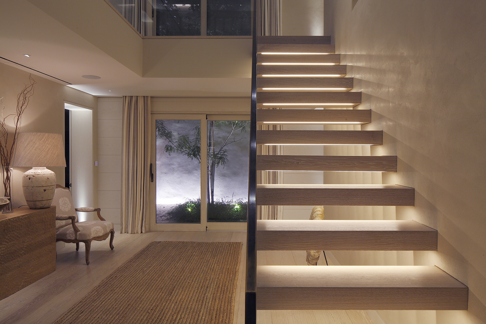 hall with underlit stairs and uplit courtyard beyond