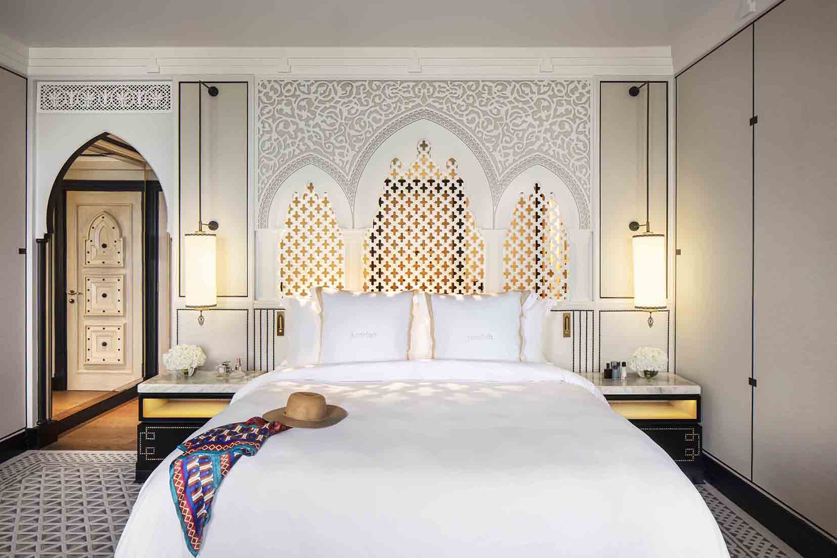 hotel bedroom with decorative pendants and backlit arches