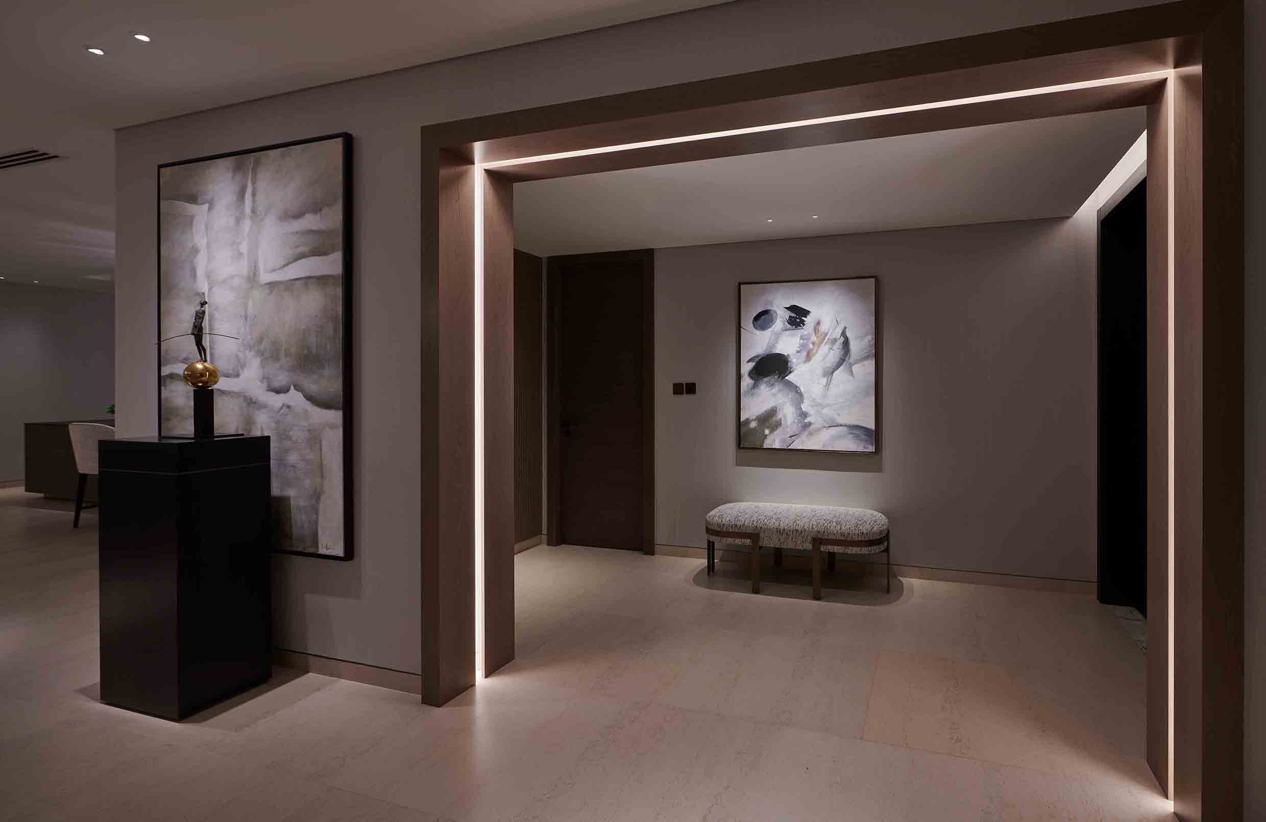 moody hall lighting with concealed linear lighting around the door frame and lighting to art