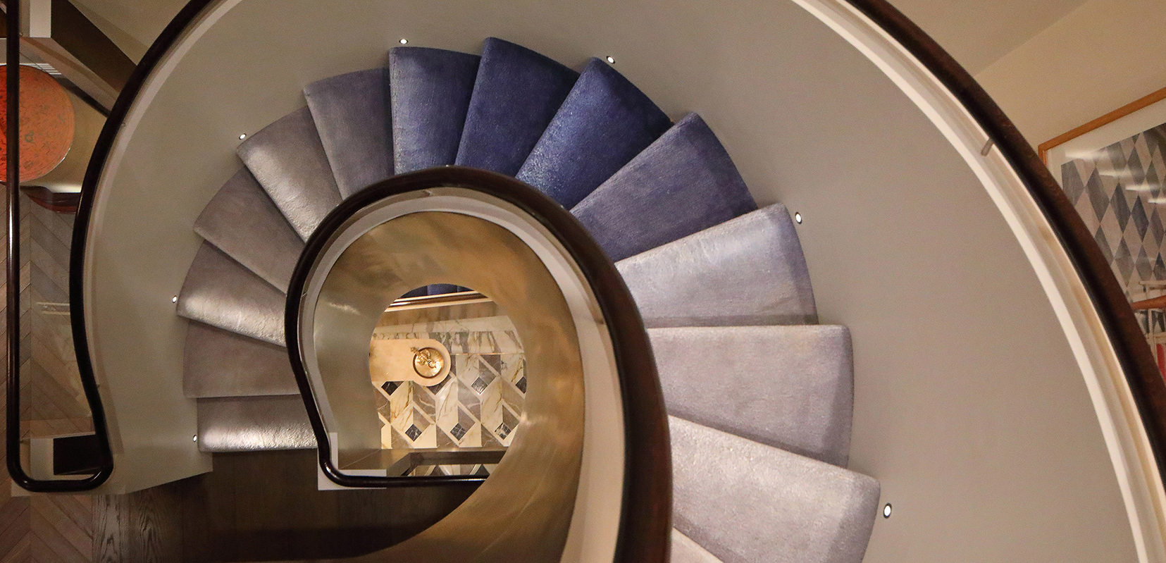 Curved staircase with low level light skimming across every third tread