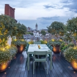 rooftop garden with table and uplit planters with soft planting