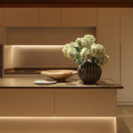 sleek kitchen with strong lines of light above and below the kitchen island