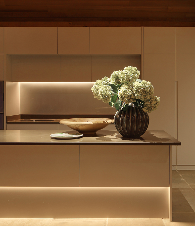 sleek kitchen with strong lines of light above and below the kitchen island