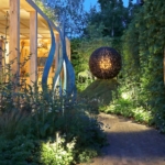 Sculptures surrounded by lit planting
