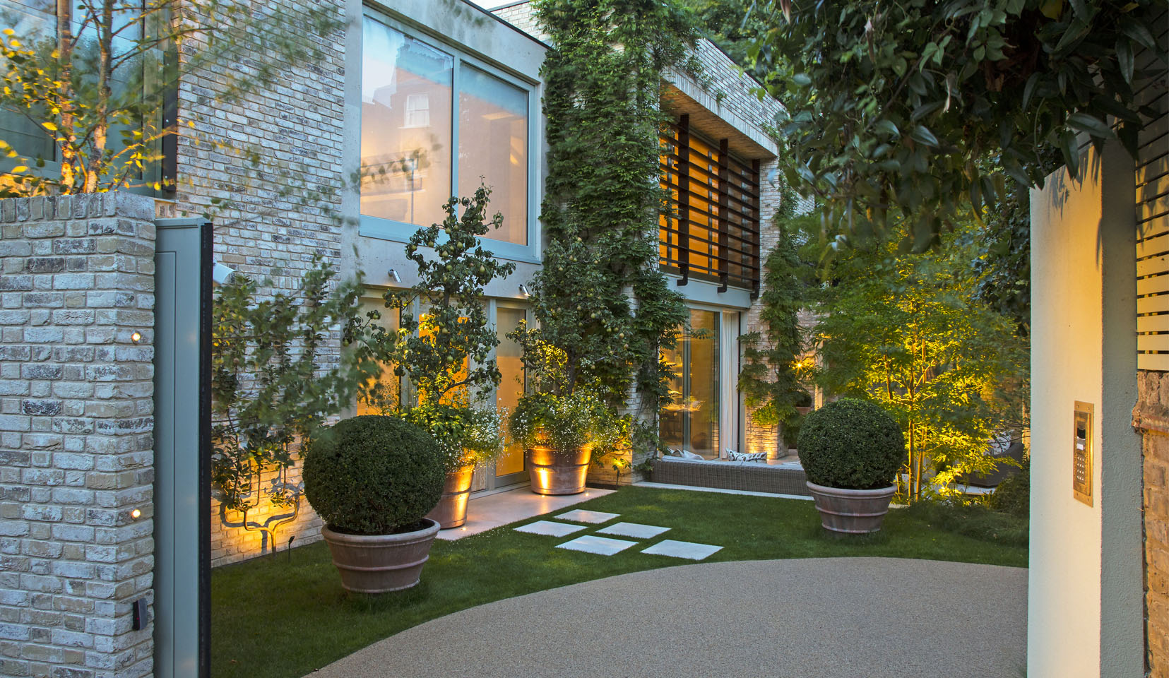Entrance to new build house with large planter uplit in doorway