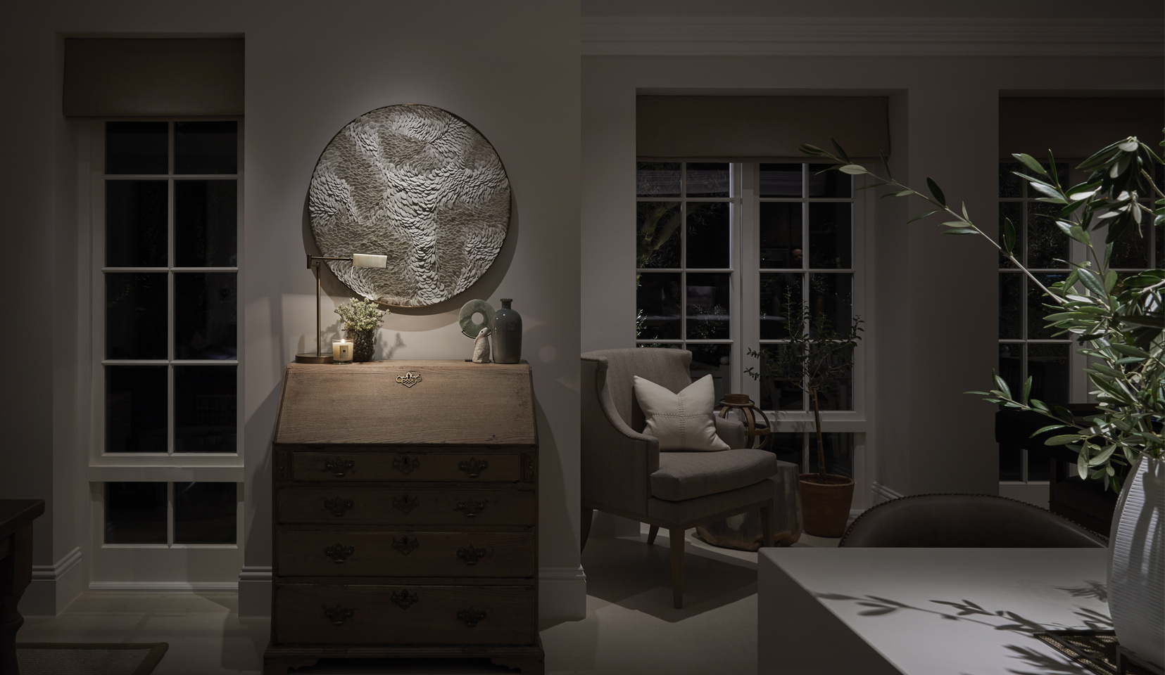 textured artwork lit with downlight above desk
