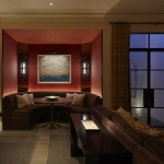 Entertainment room with booth seating area and pool table and light wells lit with uplights