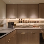 Kitchen units lit with downlights and under counter linear lighting onto kitchen surfaces