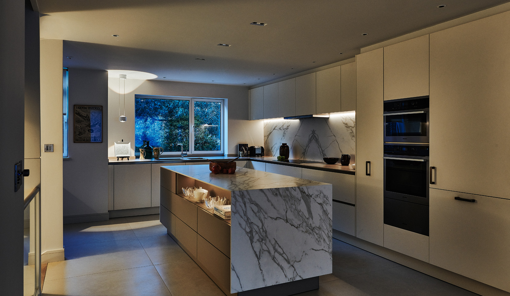 softly lit kitchen at dusk with marble island