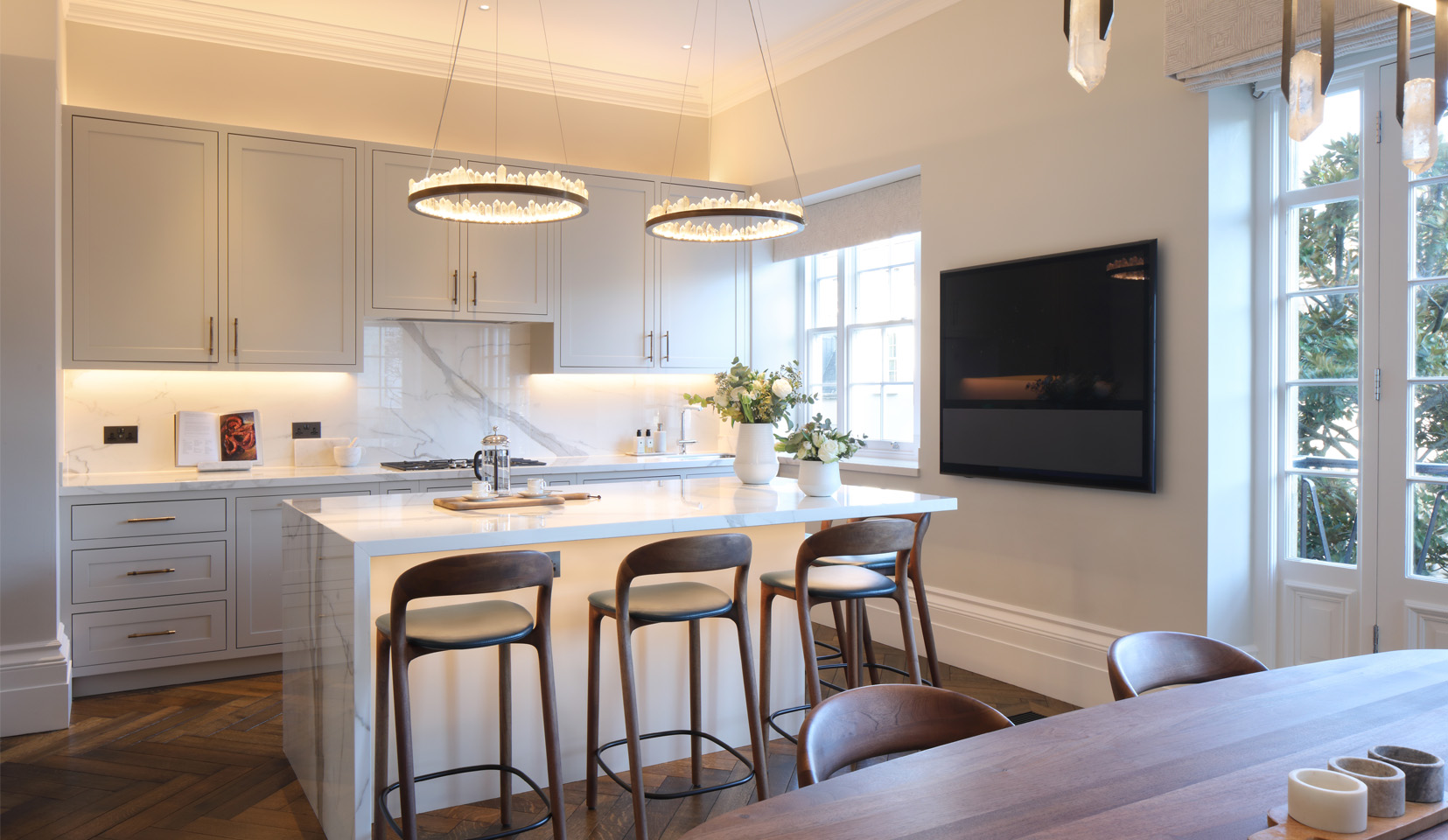 Kitchen island with pendants above and countertops lit with linear light beyond