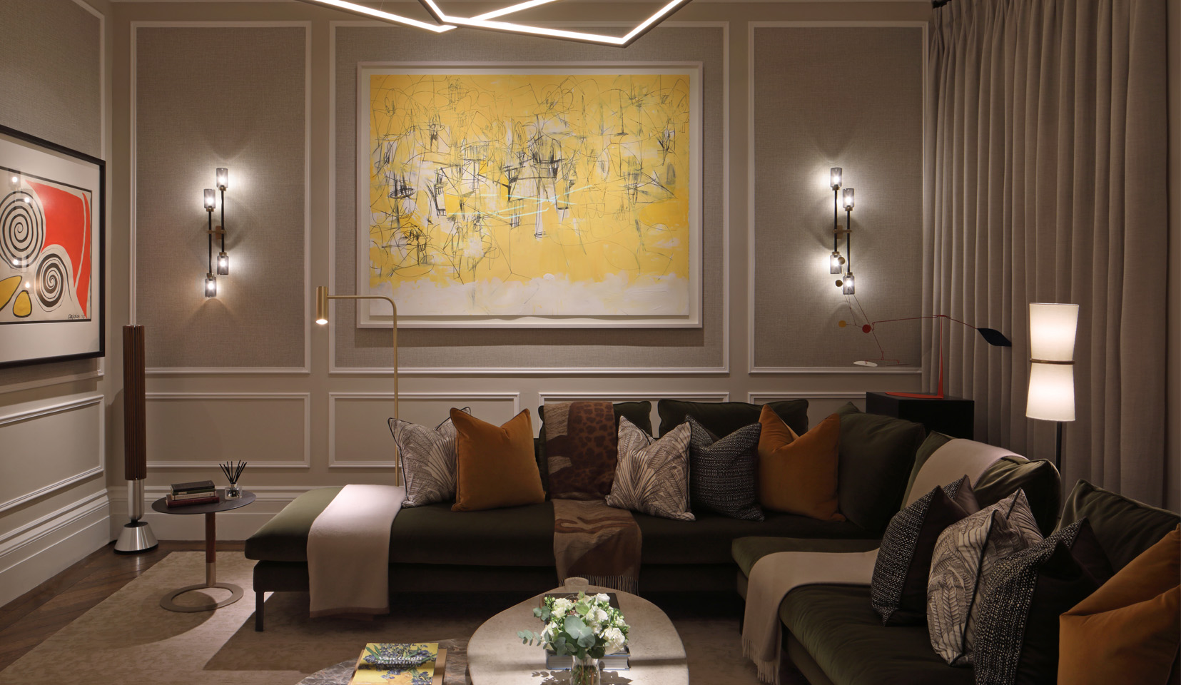 Living room with decorative pendants and spotlights to light artwork and spotlight coffee table flowers