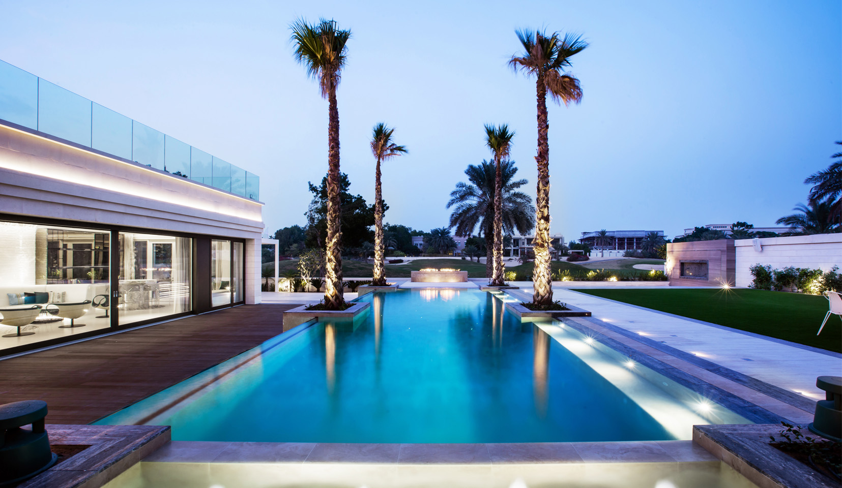 Lit up pool with palm trees
