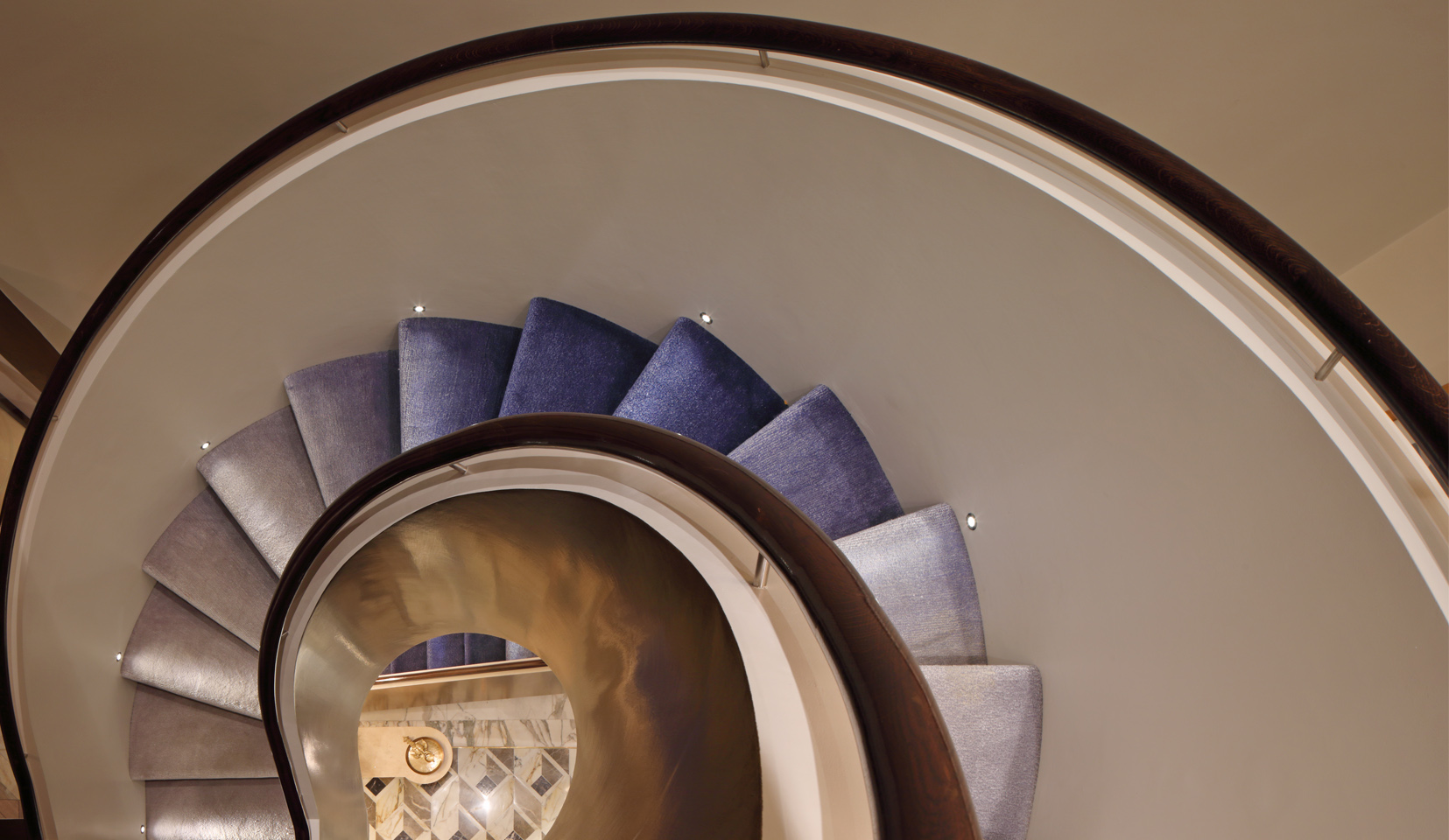 blur ombre carpeted spiral staircase with step lights every other tread