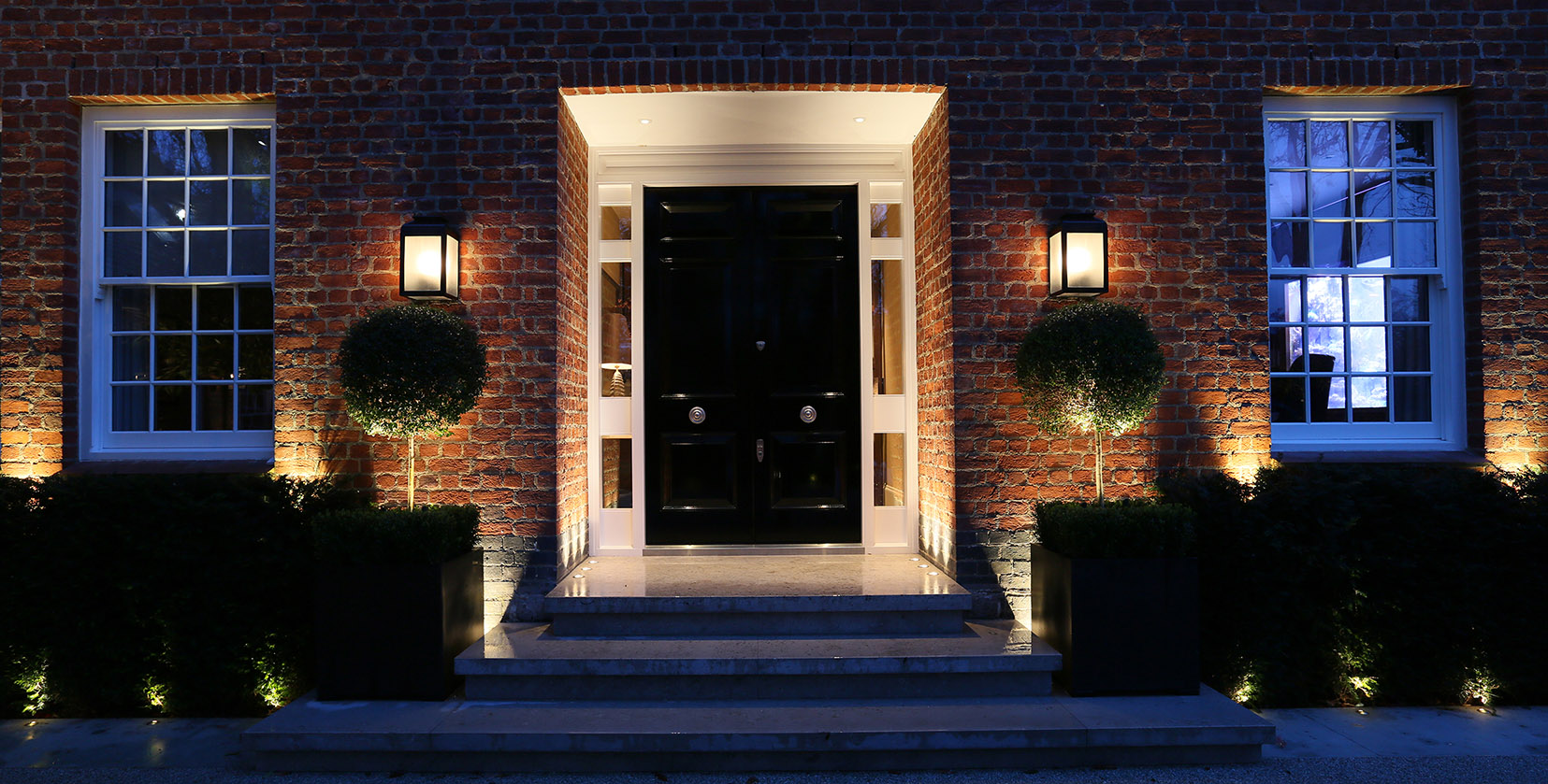 symmetrical front door with lanterns and uplights