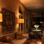 conservatory with two floor standing lights and view down to spotlit flowers at the end