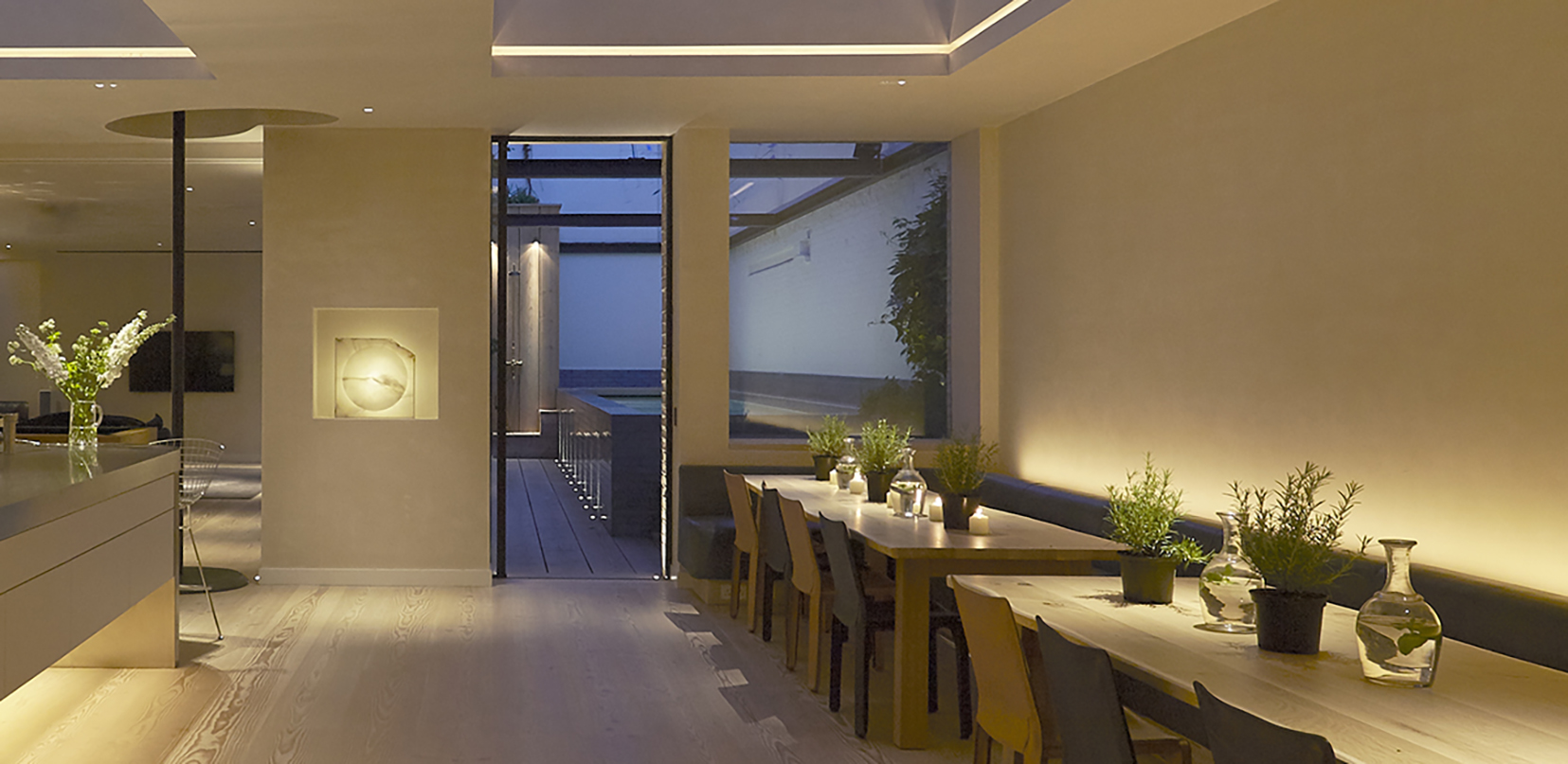 contemporary dining area with light behind banquette