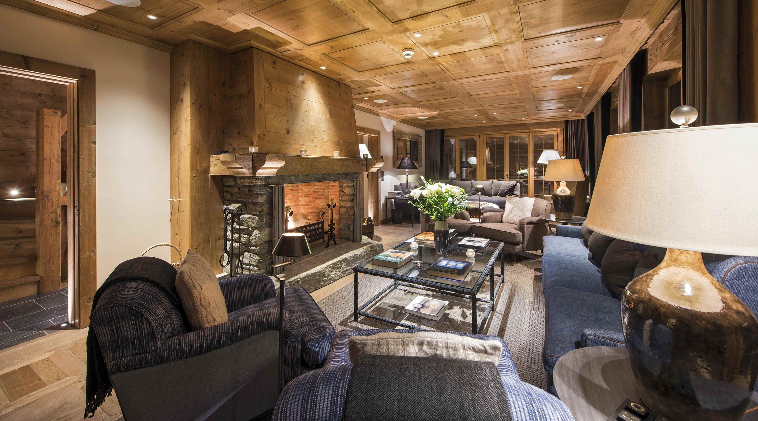 chalet living room with traditional wooden ceilings and open fireplace