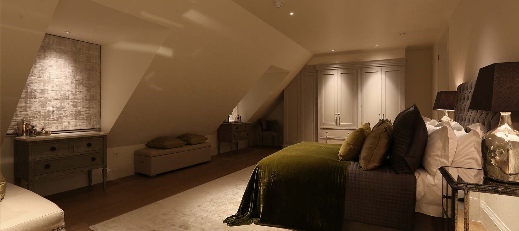 loft bedroom with downlit cupboards
