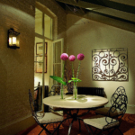 decorative lantern beside table with lit flowers and art
