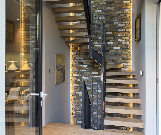 brick wall behind staircase with lighting from either side