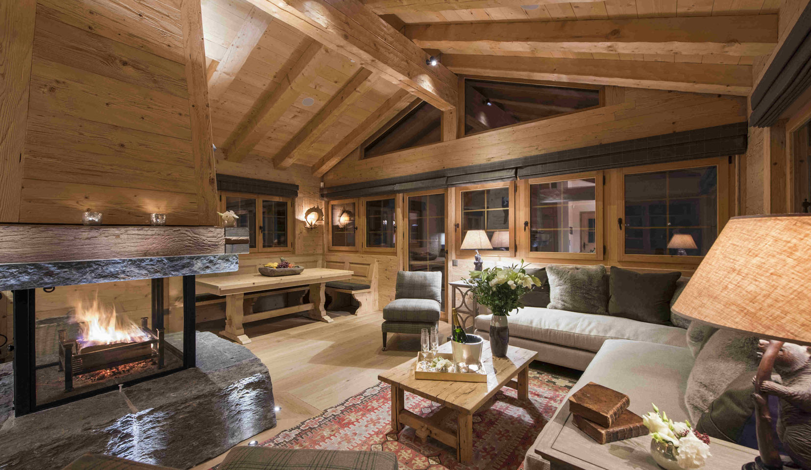 seating area in cosy chalet with arched beams lit with spotlights