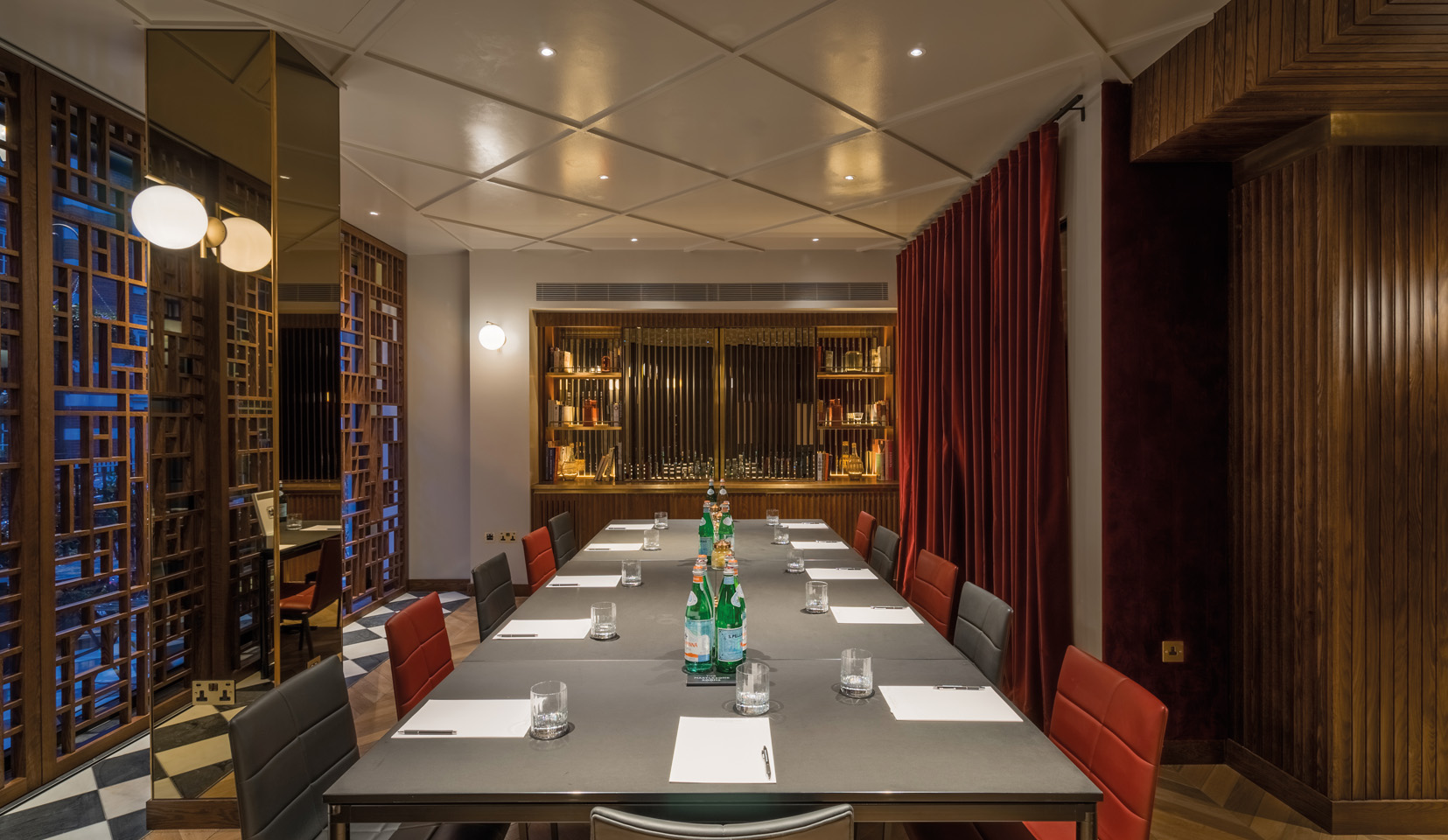 Conference room in hotel with red curtains and downlights onto table