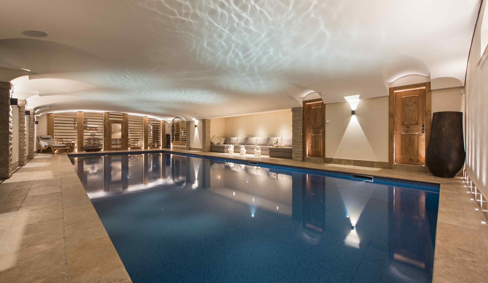 Luxurious swimming pool in chalet with uplights to walls