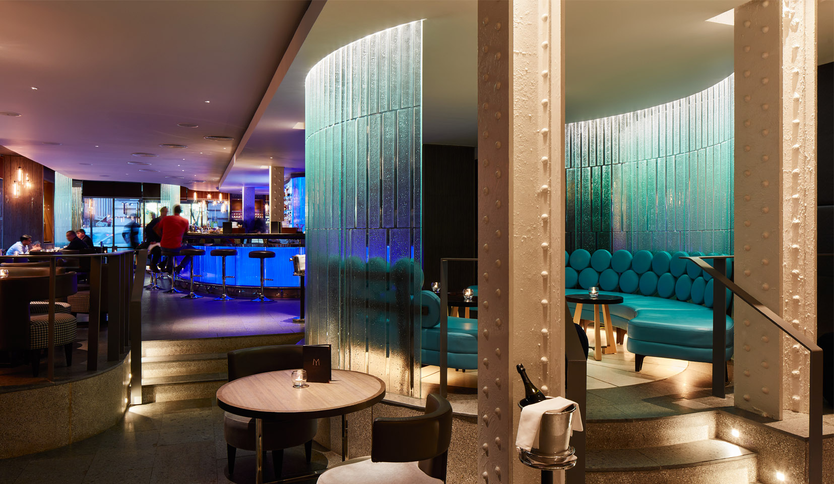 Seating area in hotel bar with blue light on curved glass wall