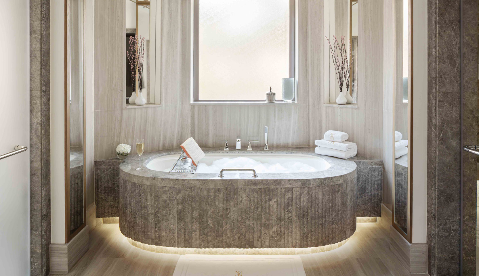Floating marble bath with light surrounding the base