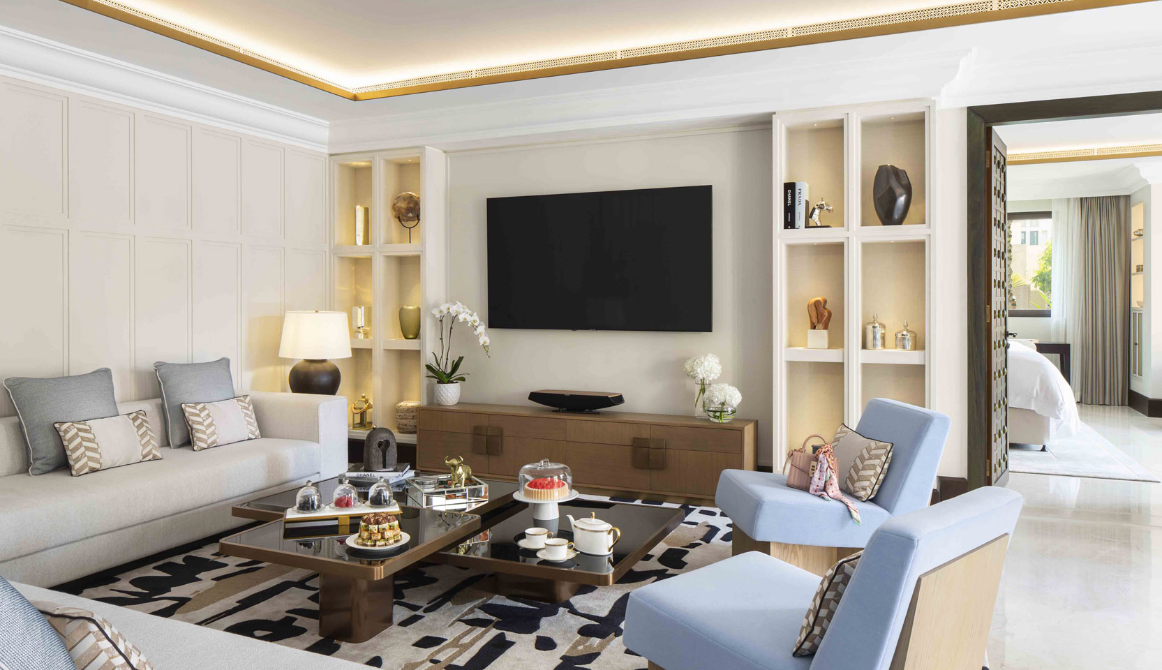 Living area of hotel with cove lighting concealed in ceiling