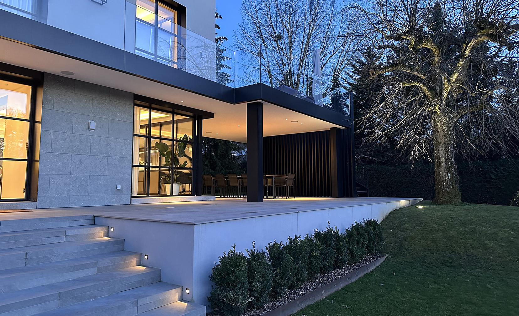 contemporary exterior with step lights and uplit tree